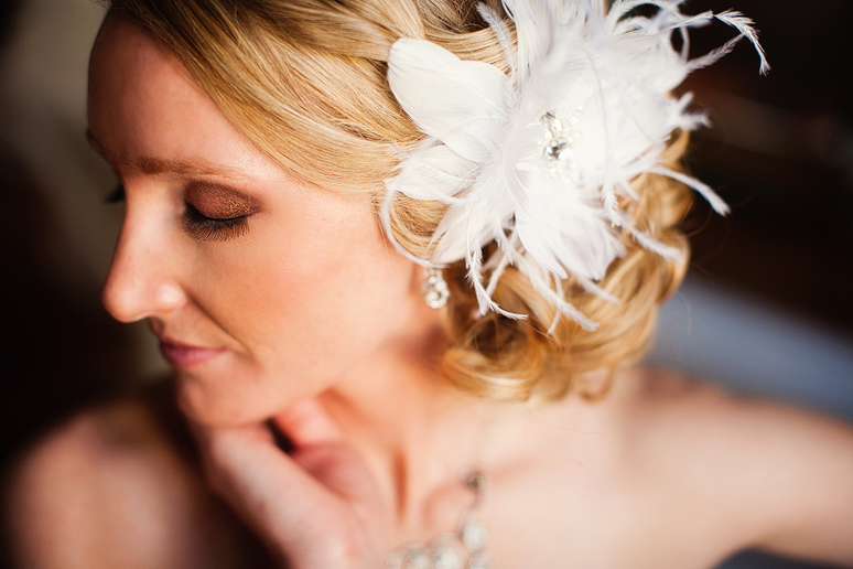 close up of a bride with a beautiful feather hair piece for her wedding day style