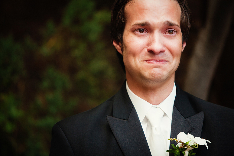 groom crying as his bride walks down the aisle at an outdoor wedding ceremony in Dallas by Allison Davis Photography