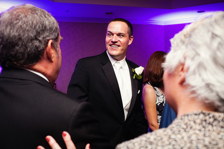 groom visiting with guests at a wedding reception at a country club photographed by Dallas wedding photographer Allison Davis Photography