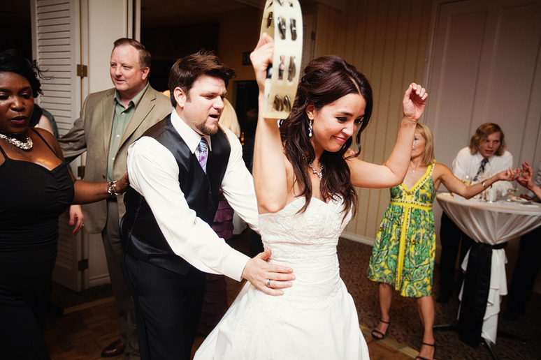 bride and groom dancing in a conga line at their wedding reception at the canyon creek country club in richardson texas