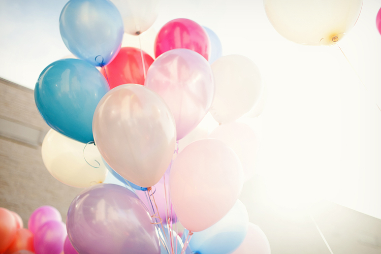 bridesmaids passing out balloons for guests to send off balloons for bride and groom's grand wedding exit