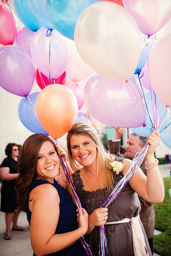 bridesmaids passing out balloons for guests to send off balloons for bride and groom's grand wedding exit